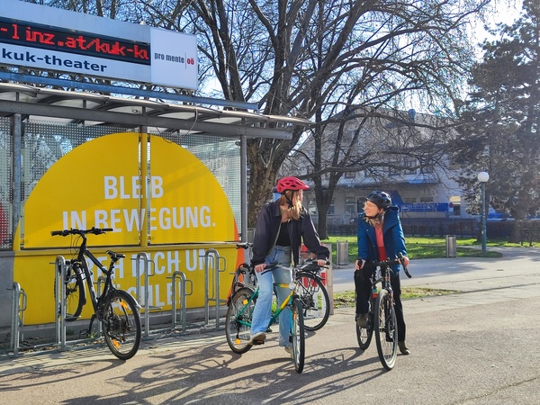 Bild rechts zeigt die begeisterten Radlerinnen Sophie Etzlsdorfer (Nachhaltigkeitsmanagerin) und Margarete Jungwirth (Mitarbeiterin Betriebliche Gesundheitsförderung)